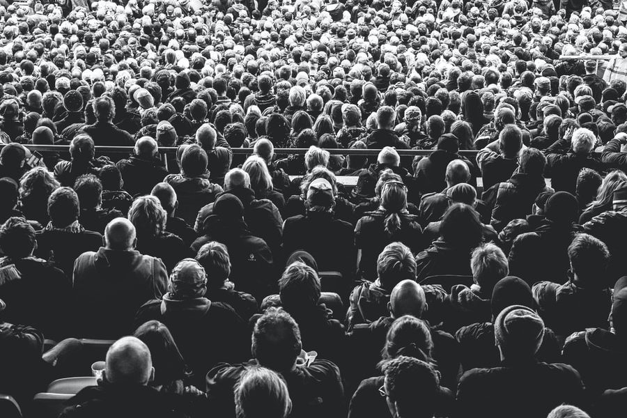 grayscale photo of people sitting on chair