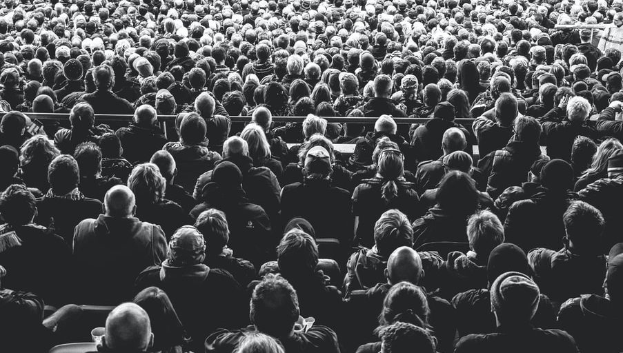 grayscale photo of people sitting on chair